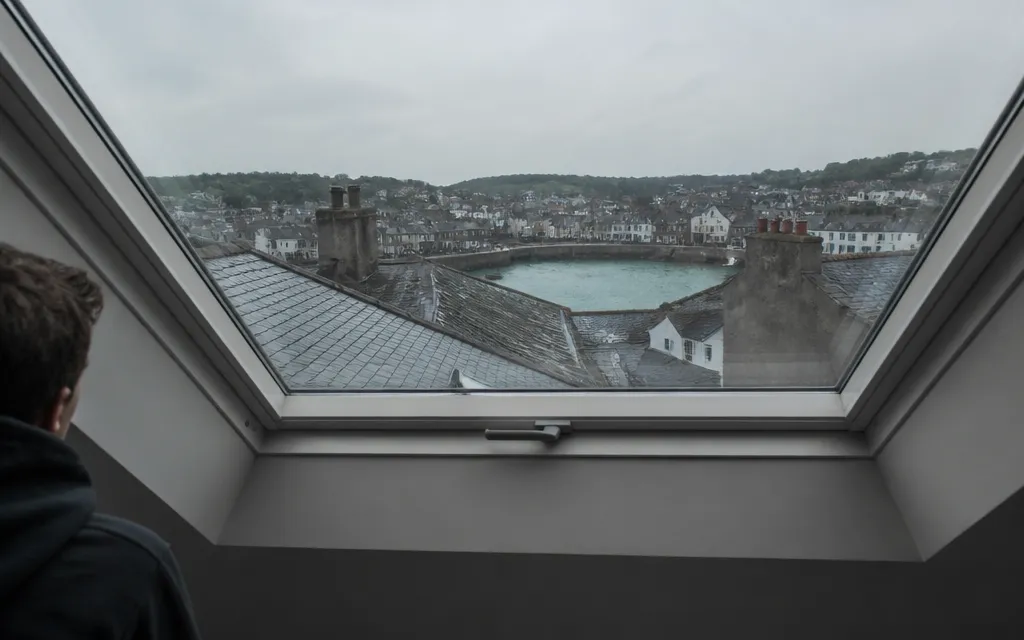 Fenêtre de toit vue de l’intérieur d’un comble aménagé, ébrasement en plaques de plâtre autour du cadre